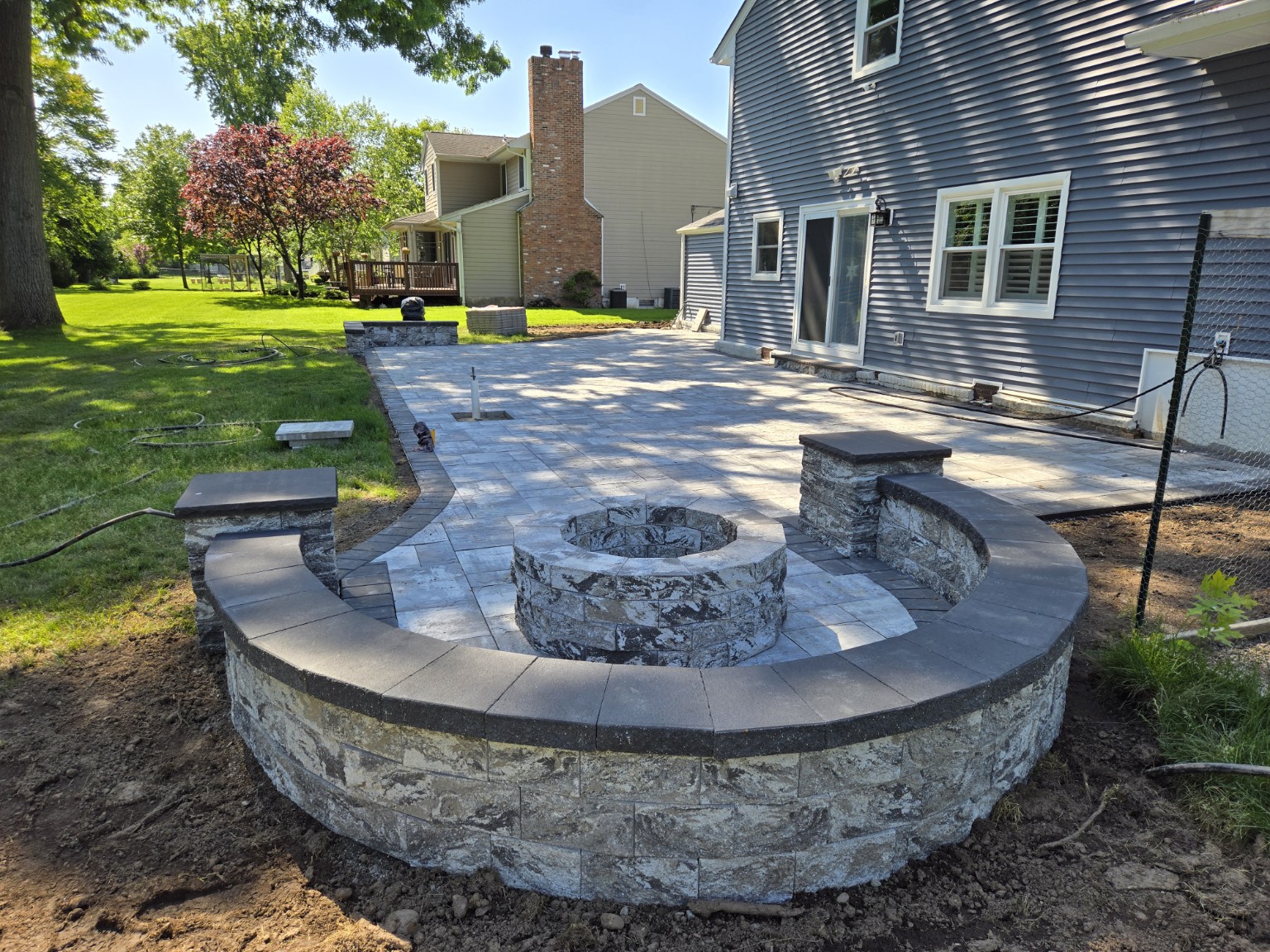Curved seating wall around a stone fire pit